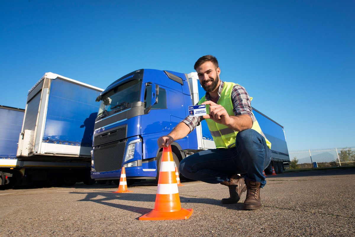 Truck driver standing confidently next to a commercial vehicle