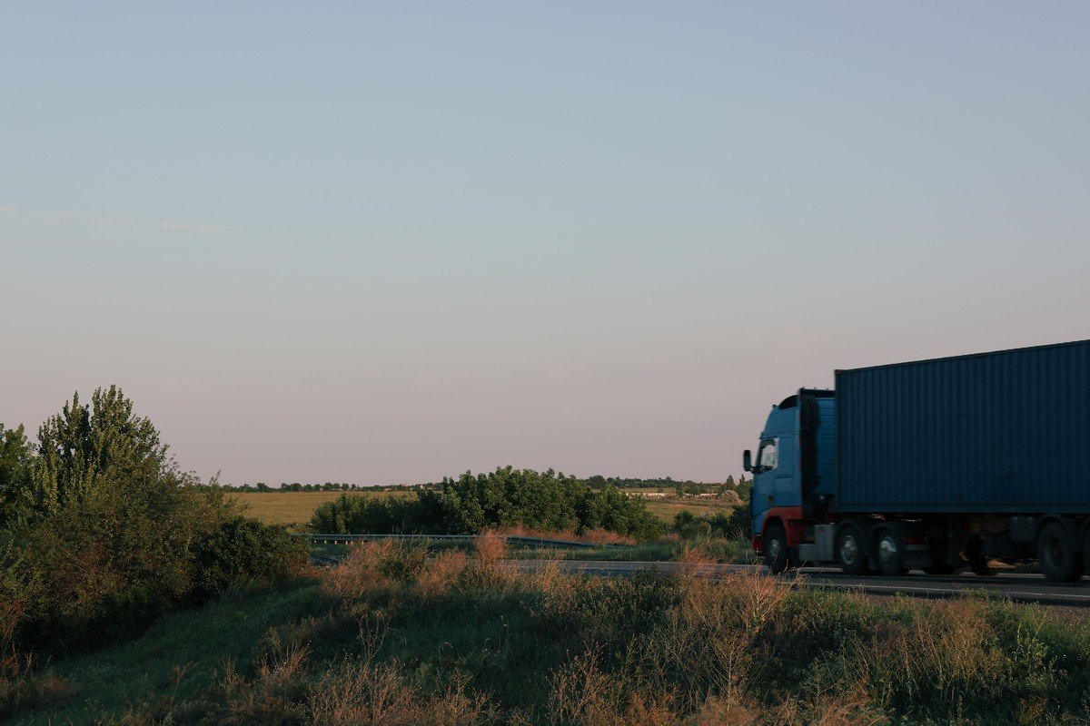 Semi-truck driving on a highway through fields